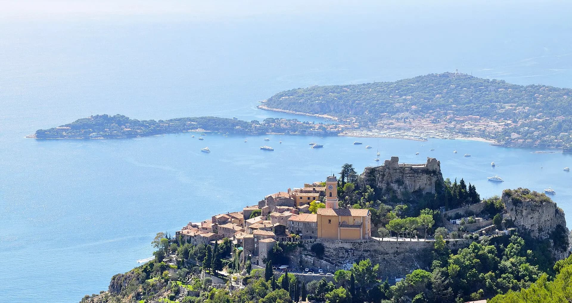 Das Bergdorf Èze auf seinem Felsen über dem Meer, dahinter die Halbinsel Cap Ferrat, gesehen von der Grande Corniche