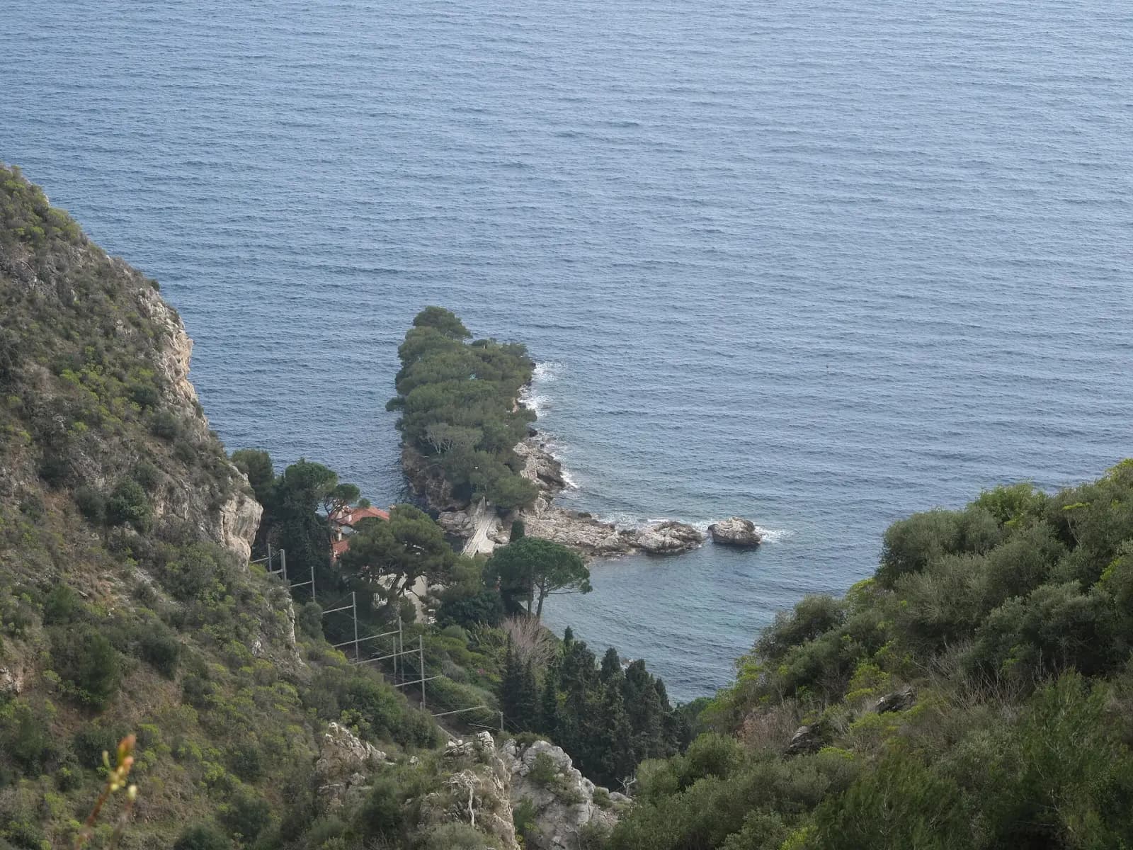 Vue plongeante depuis le chemin de Nietzsche sur une pointe boisée et la mer à Èze-sur-Mer