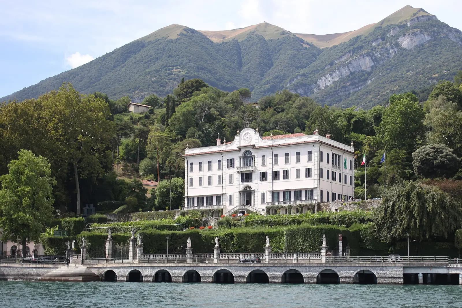 Die weiße Fassade der Villa Carlotta über ihren Gärten und dem Seeufer in Tremezzo
