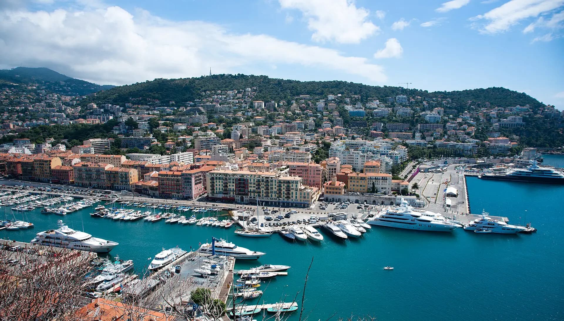 Port Lympia with its boats and the colourful façades of the harbour district, Mont Boron in the background
