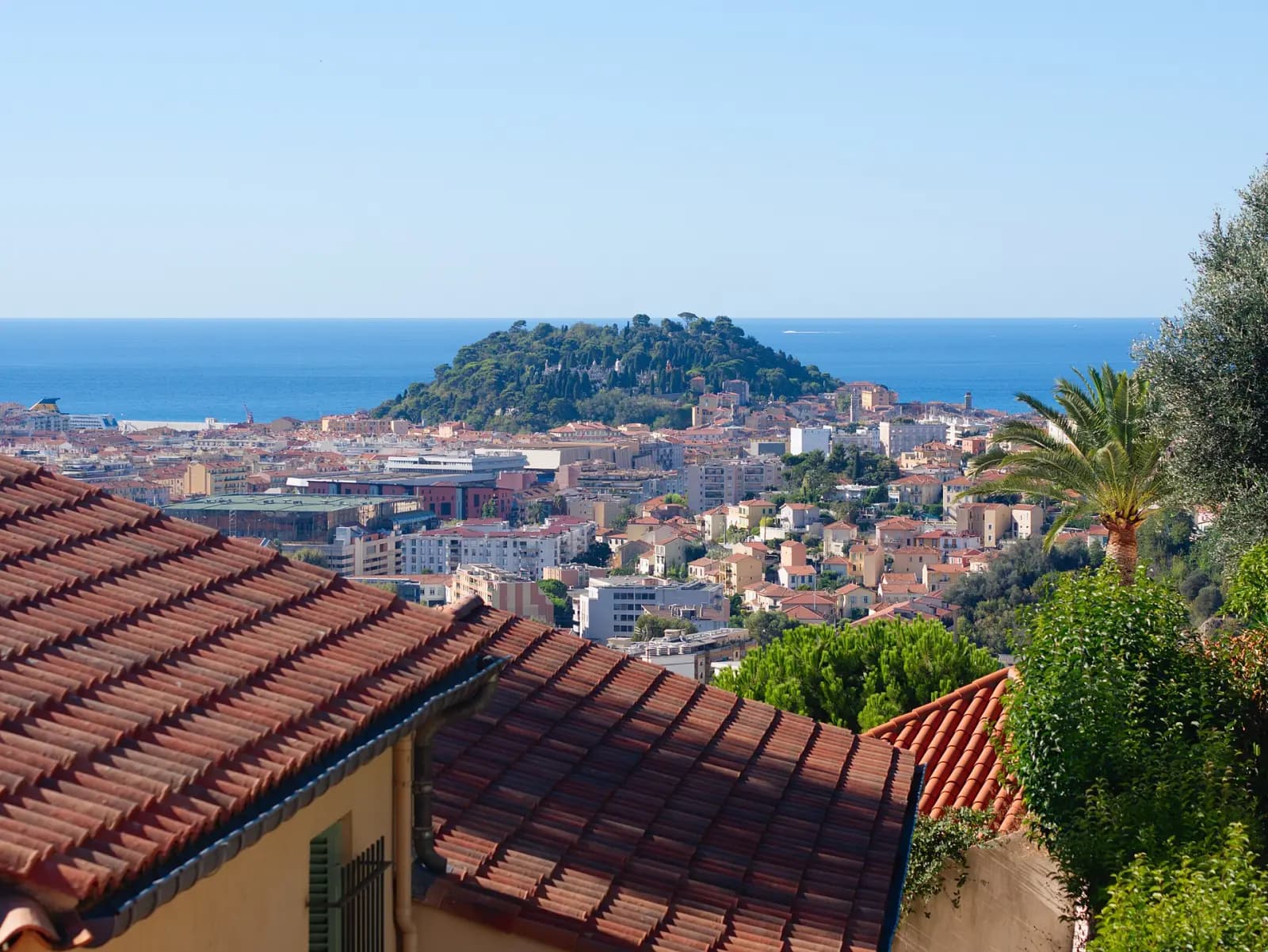 Castle Hill and its pines above the rooftops of Nice and the sea, seen from the heights of Cimiez