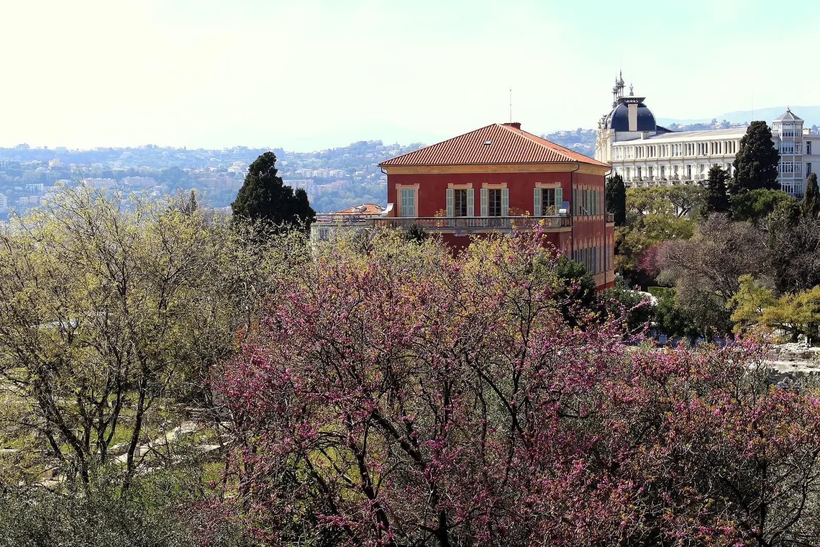 The red villa of the Matisse Museum among blossoming trees, seen from the Cimiez monastery garden