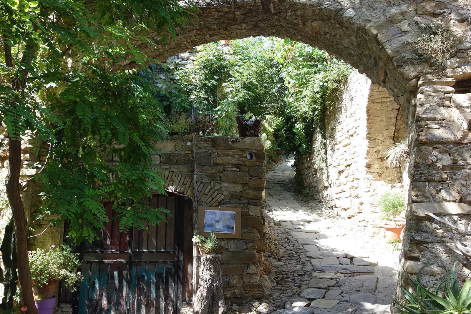 Arco de piedra cubierto de vegetación en Bussana Vecchia