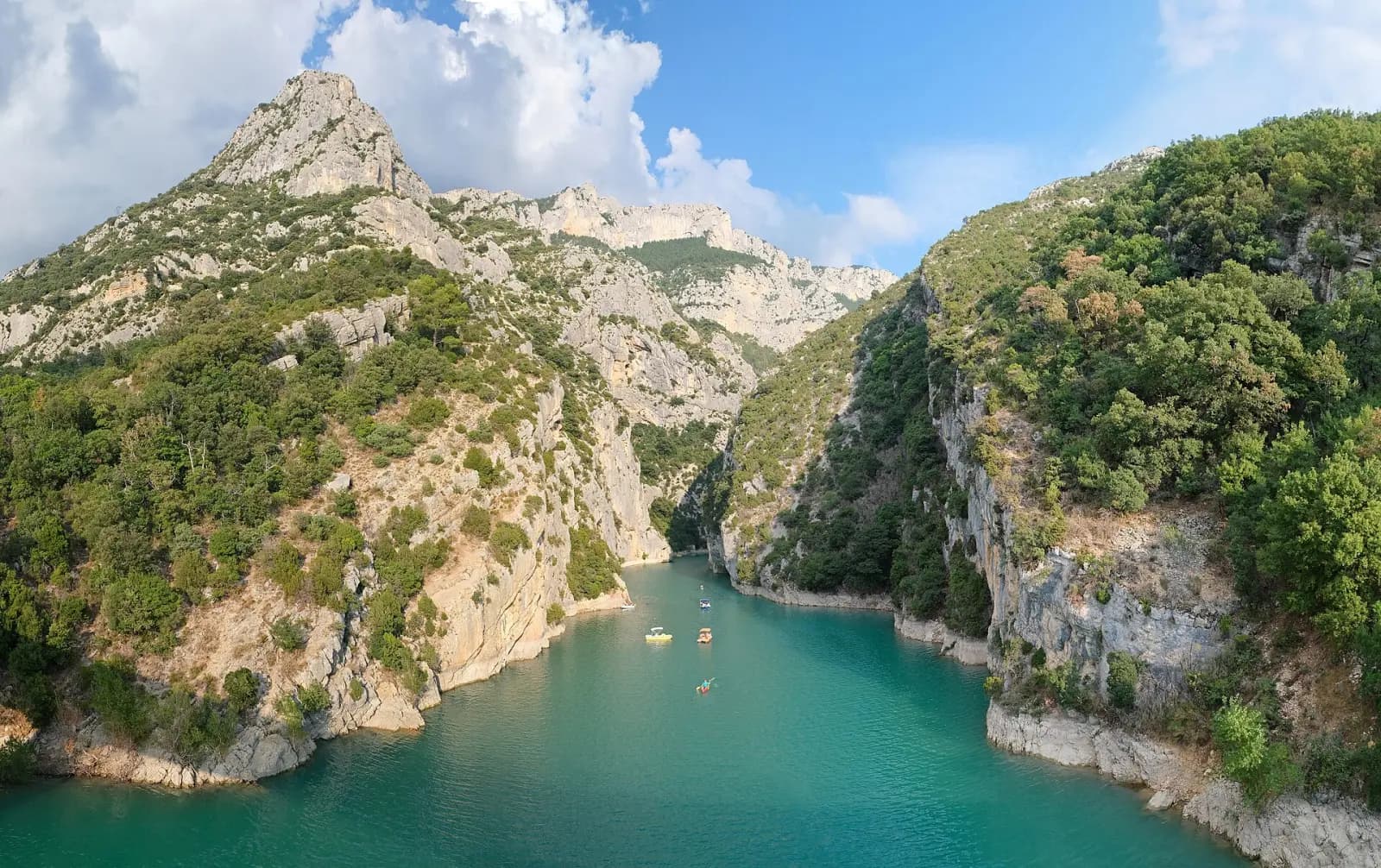 The turquoise Verdon at the bottom of a narrow passage of limestone cliffs and wooded slopes