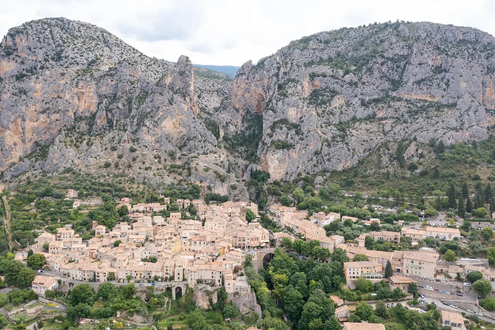 Aerial view of Moustiers-Sainte-Marie, its tiled roofs and the two cliffs framing it